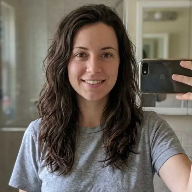 Client selfie showing wavy dark brown shoulder-length hair